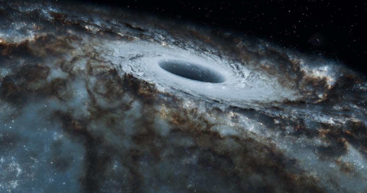 Black and white view of a black hole surrounded by swirling stars in a spiral galaxy